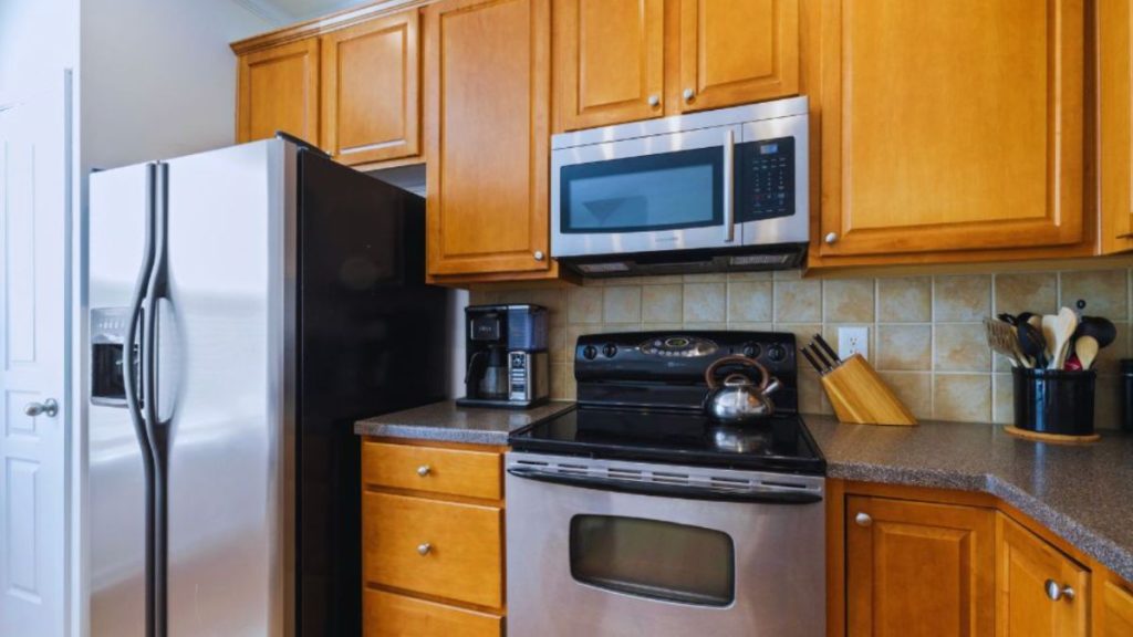 Stainless steel kitchen appliances complement warm wood cabinetry, creating a stylish and functional cooking space.