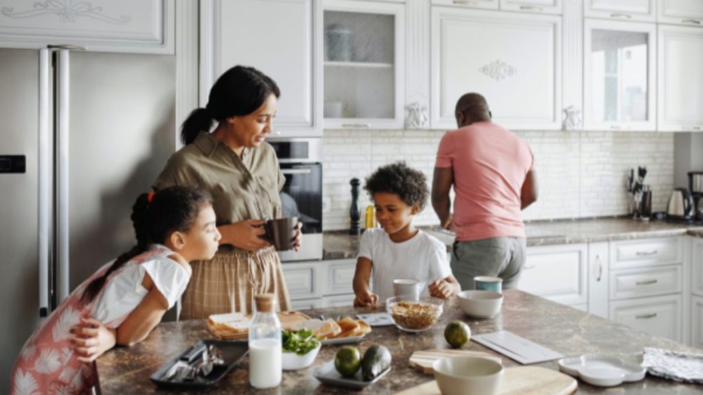 In a kitchen, a family enjoys food together, with visible cabinets and smart storage solutions enhancing the space.
